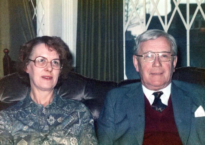 An older couple sitting on a sofa